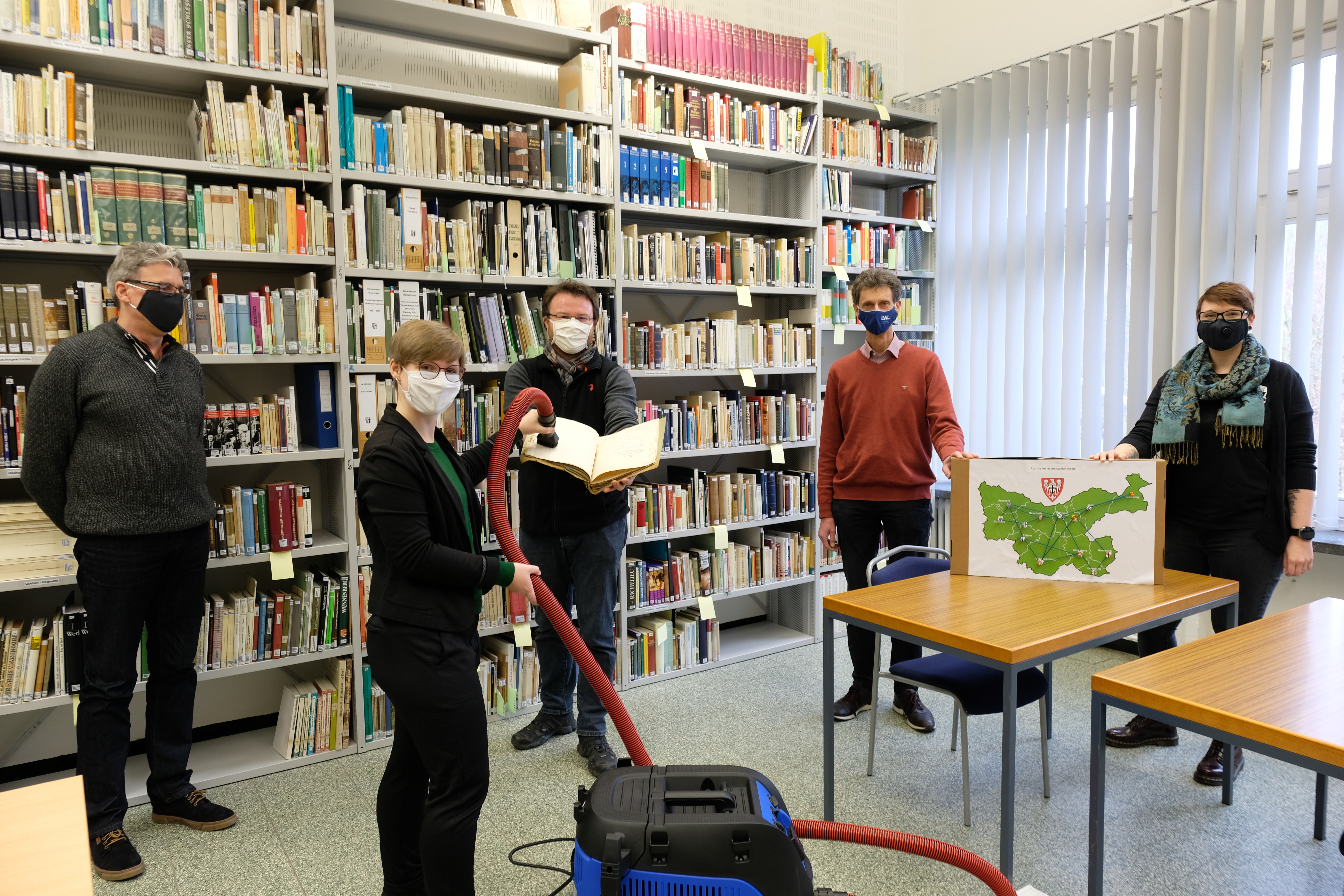 v.l.n.r: Robert Schultze (Stadtarchiv Meschede), Susi Frank (Kreisarchiv des Hochsauerlandkreises), André Algarve (Stadtarchiv Meschede), Dr. Gunnar Teske (LWL-Archivamt), Rebecca Krause (Kreisarchiv des Hochsauerlandkreises) nehmen den Archivstaubsauger mit Mindestabstand und Mund-Nasen-Bedeckung stellvertretend entgegen.